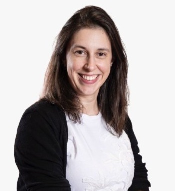 Fot de Marcela Rodrigues, com cabelos longos e castanhos, sorrindo e olhando diretamente para a câmera.